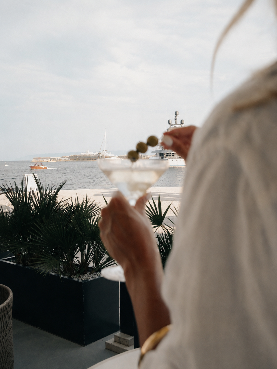 Woman holding a martini glass overlooking the marina